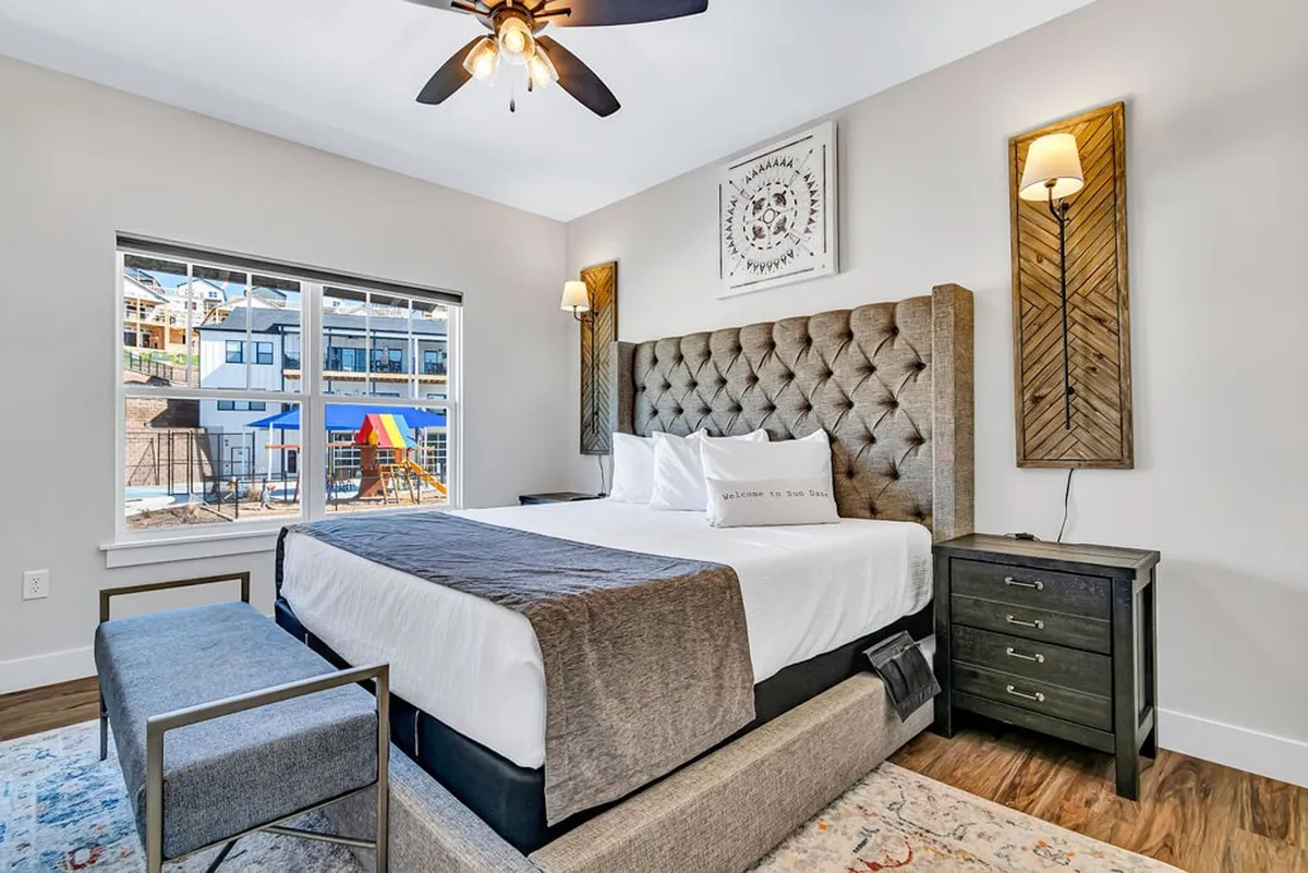 A stylish bedroom featuring a comfortable bed, a window framing a gentle view, and subtle wall art. The space feels cozy and intimate, ideal for restful nights and peaceful mornings.