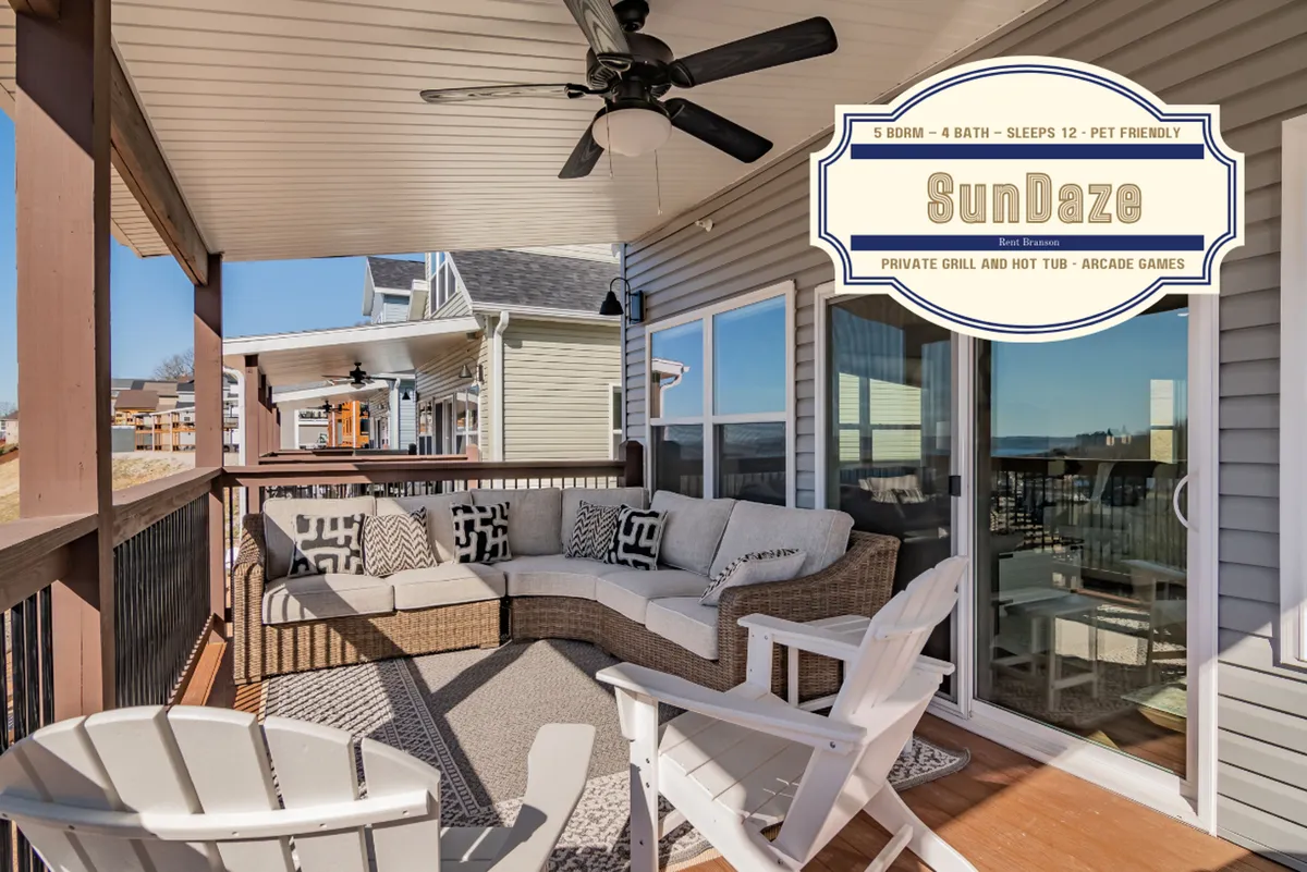 This image showcases a cozy outdoor seating area complete with a modern fan, a prominent Char-Broil gas grill, and the inviting presence of a hot tub. The setting exudes a casual and cozy ambiance, perfect for socializing or sharing meals against a beautiful backdrop.